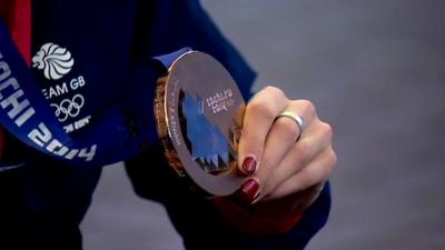 One of Scotland's curling team holding a Winter Olympics medal