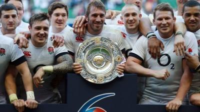 England players celebrate beating Wales with the Triple Crown trophy