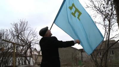 Rasim Bekirov with the flag of the Crimean Tatar people