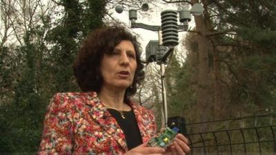 Female holding Raspberry PI computer in front of a school weather station