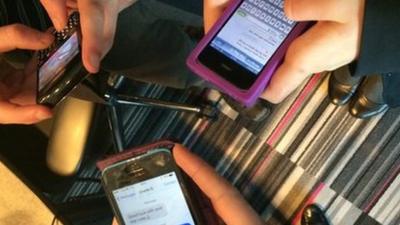 Three smart phones held in hands