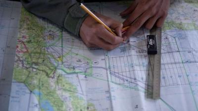 Royal Malaysian Air Force Navigator captain marks locations on a map