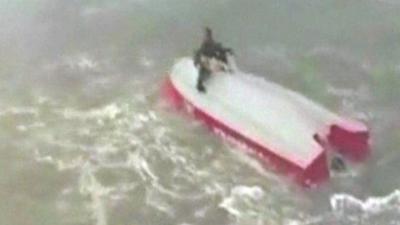 Man sit on upturned boat with dog