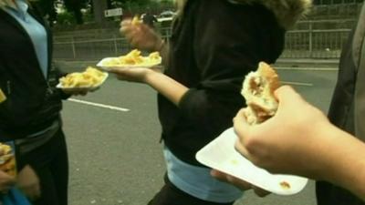 Anonymous children eating chips and burgers