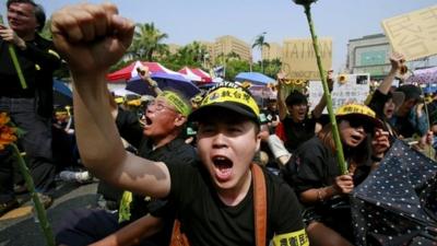 Protesters denounce the controversial China Taiwan trade pact during a mass protest in Taipei, 30 March