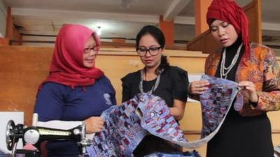 A piece of batik cloth is inspected at the prison workshop