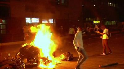 Protesters set fire to a police motorcycle