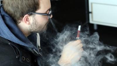 A man smokes an e-cigarette