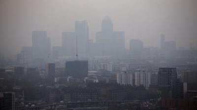 The skyscrapers of the Canary Wharf business district in London are shrouded in smog