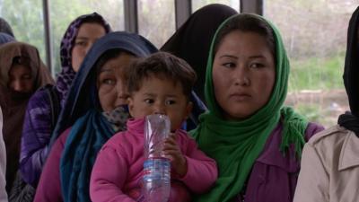 Woman with young child in voting queue