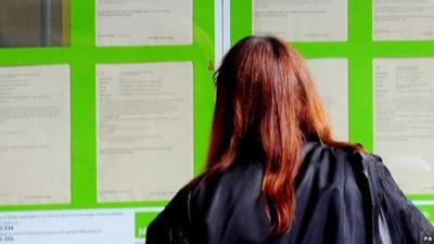 Woman looking posters in a job centre