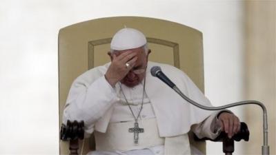 File photo: Pope Francis touches his forehead after delivering his message during the general audience in St. Peter's Square, at the Vatican, 9 April 2014