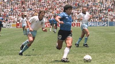 Diego Maradona powers through the England defence to score for Argentina