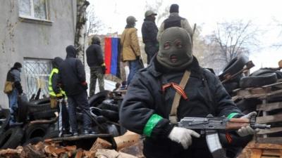 Pro-Russia protesters guard a barricade outside a regional police building seized by armed separatists in Sloviansk