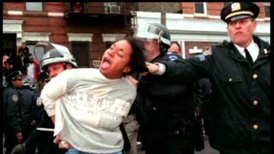 Still of someone having the hair grabbed by a NY police person