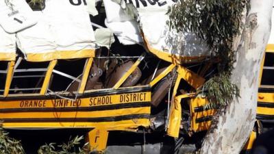 The wreckage of a school bus is seen as it leans against a eucalyptus tree, after it veered off the road in Anaheim, California April 24, 2014