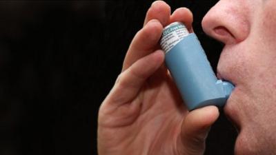 Asthma sufferer using an inhaler