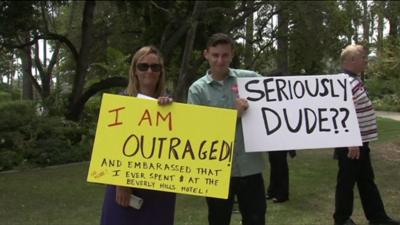 Protestors hold signs outside the Beverley Hills Hotel