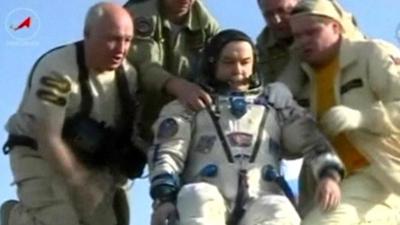 Mikhail Tyurin is helped out of the space capsule