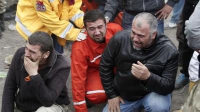 Relatives of miners who were killed or injured in a mine explosion react as rescuers work in Soma