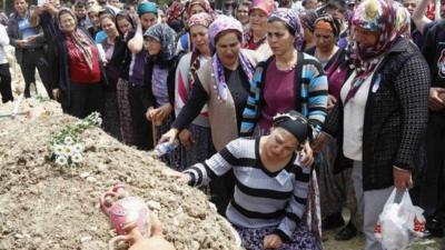 Women mourn at a cemetery in Soma, Turkey, during the funeral of a miner who died in a fire at a coal mine on Tuesday