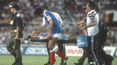 France's Patrick Battiston is stretchered off the pitch after being fouled by West Germany goalkeeper Harald Schumacher