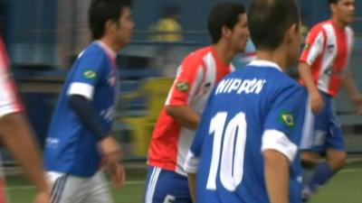 Football players from Paraguay and Japan on a pitch