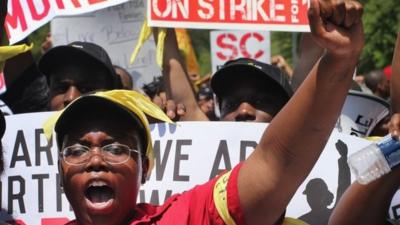 Fast food workers and activists demonstrate outside the McDonald's corporate campus in Oak Brook, Illinois