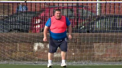 Man standing in football goal