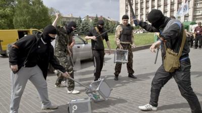 Pro-Russian militants smash ballot boxes in front of the seized regional administration building in Donetsk