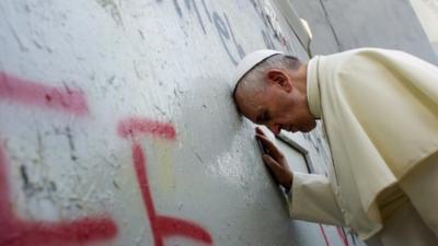 Pope Francis touches the wall that divides Israel from the West Bank