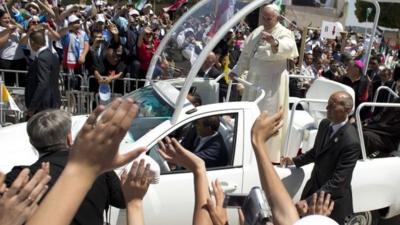 Pope Francis waves to the crowd, from his pope-mobile