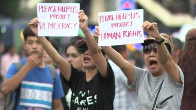 Protesters holding messages in English