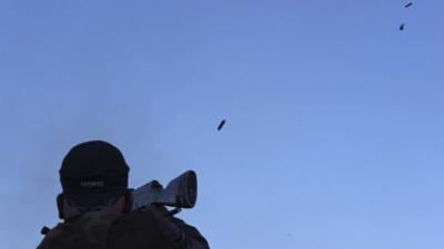 A rebel fighter fires his weapon during what rebels say is a clash with forces loyal to Syrias President Bashar al-Assad in the village of Tshalma near the Armenian Christian town of Kasab May 11, 2014