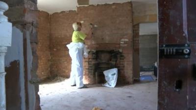 Plaster being removed from a wall