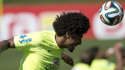 Brazilian national football team player Dante heads the ball during a training session