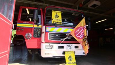 A fire engine with picket line signs