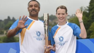 Triple gold medallist Daley Thompson hands the baton to Scottish athlete Eilidh Child on Coldstream bridge