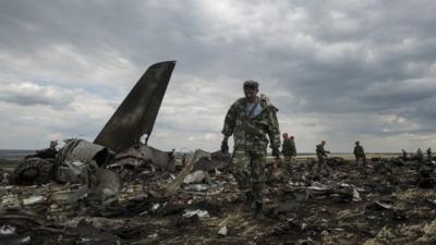 Pro-Russian fighters walk at the site of a downed Ukrainian army aircraft