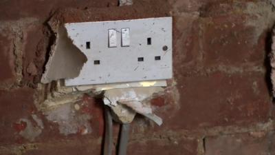 A plug socket in a bare wall