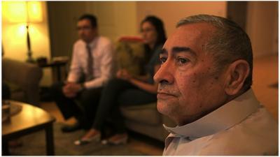 Ali Abu Khumra watches a news story about violence in Iraq with his children Tariq Abu Khumra and Sally Abu Khumra in their apartment in Glendale, California.