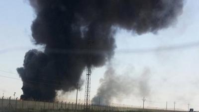 Smoke rises from a oil refinery in Baiji, north of Baghdad. 19 June 2014