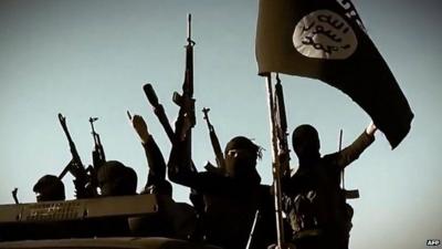 Isis militants raising their weapons as they stand on a vehicle mounted with the trademark Jihadists flag