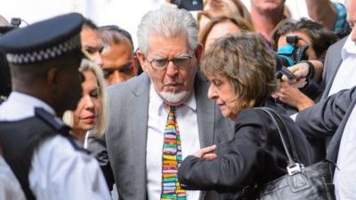 Veteran entertainer Rolf Harris, centre, accompanied by his daughter Bindi, background left and niece Jenny, centre right