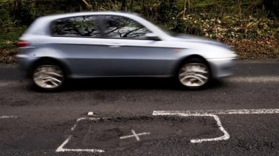 File photo dated 06/01/13 of a car on a potholed road in Gloucestershire