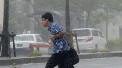 Man hurrying through rain and wind