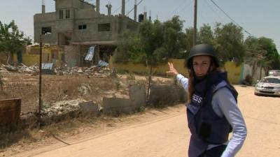 Yolande Knell pointing at damaged building