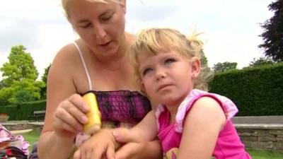 Woman putting sun cream on toddler