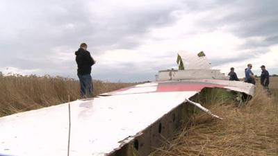 Crews stand around a plane wing