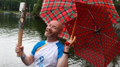 Craig Hill carries the Glasgow 2014 Queen's Baton through Bardowie in East Dunbartonshire.